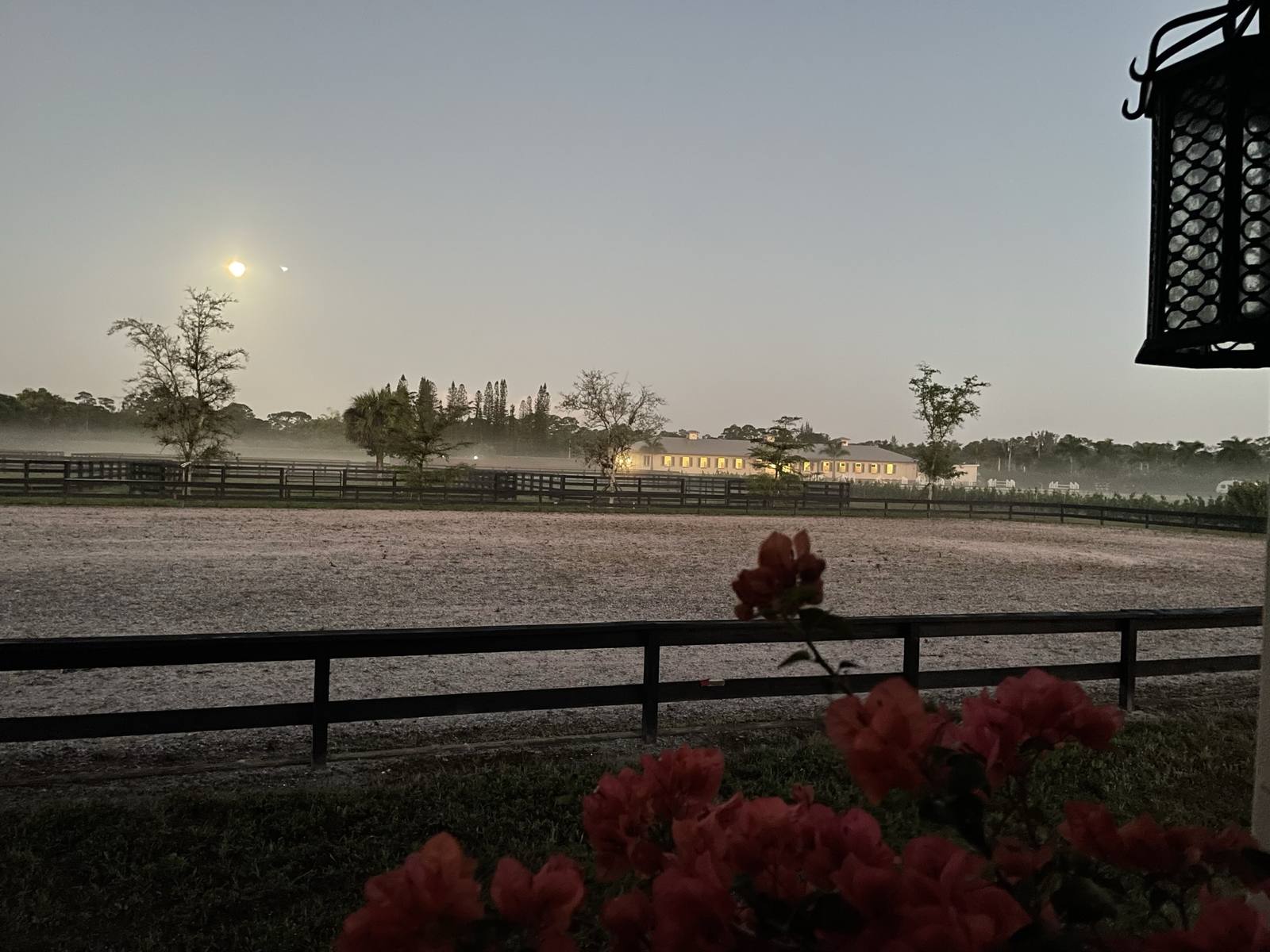 The arena at dusk with the barn beyond