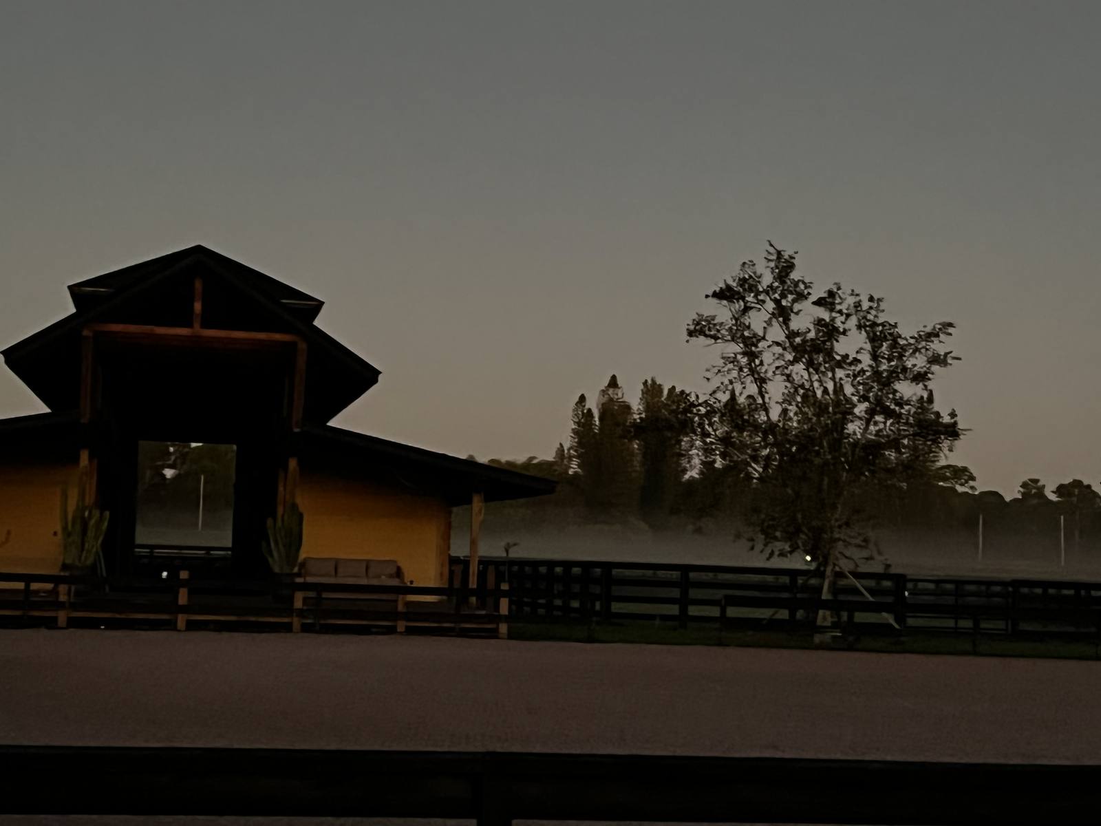The barn and arena in the evening mist