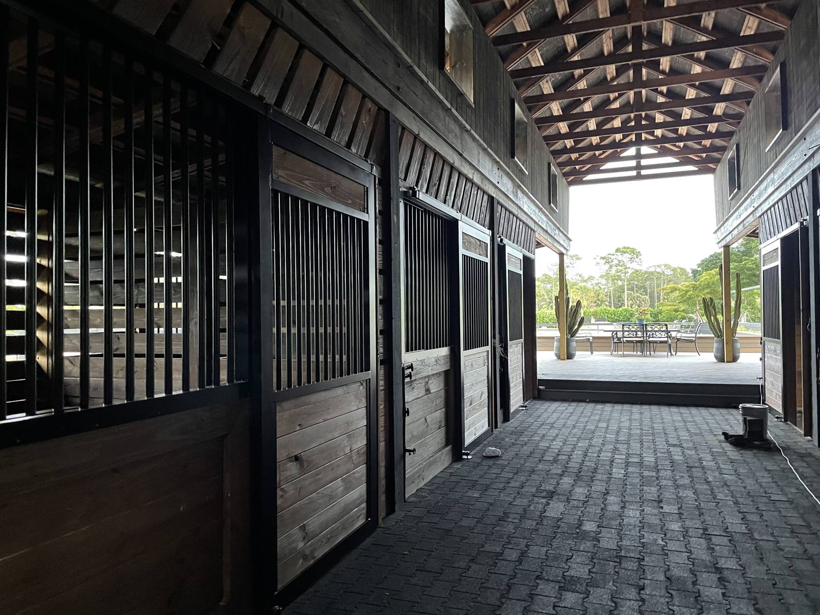 Main barn aisle opening onto the covered patio and paddocks