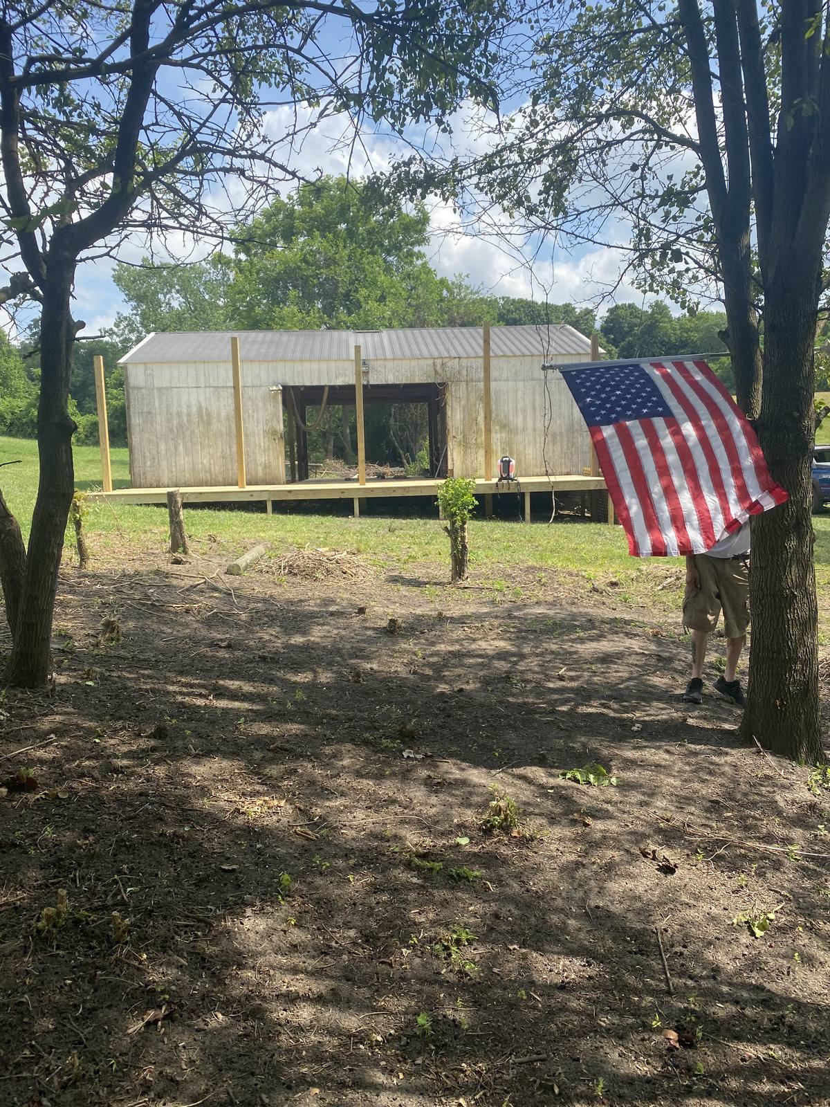The barn with an American flag among the trees