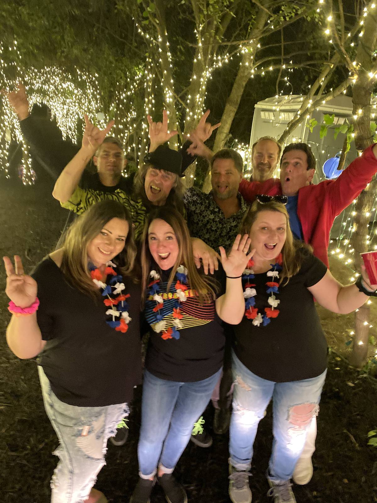Friends celebrating under the string lights at night